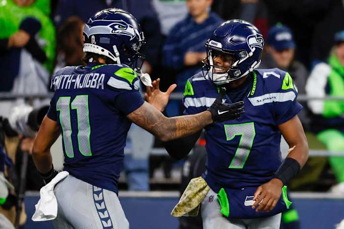 Seattle Seahawks quarterback Geno Smith (7) celebrates with wide receiver Jaxon Smith-Njigba (11) after throwing a touchdown pass against the Washington Commanders during the fourth quarter at Lumen Field.